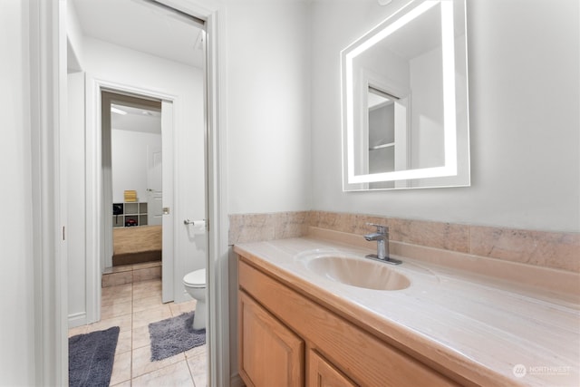 bathroom featuring tile patterned flooring, vanity, and toilet