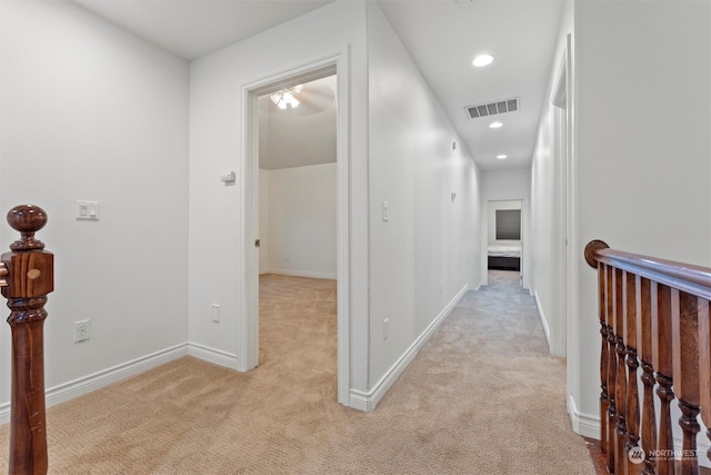 hallway featuring light colored carpet