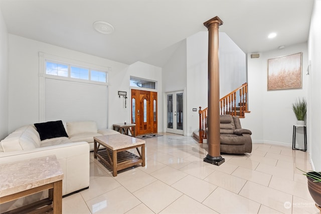 living room featuring ornate columns, french doors, light tile patterned flooring, and a high ceiling