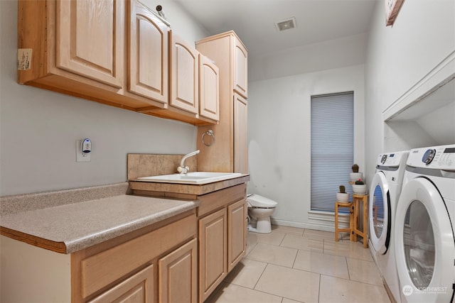 washroom with separate washer and dryer, sink, and light tile patterned floors