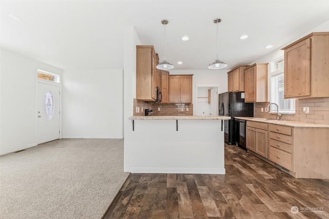 kitchen with sink, tasteful backsplash, dark hardwood / wood-style flooring, pendant lighting, and black appliances