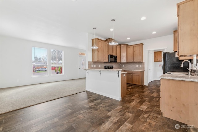 kitchen featuring black appliances, backsplash, hanging light fixtures, and dark wood-type flooring