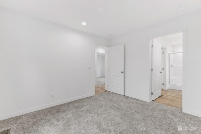 unfurnished bedroom with ornamental molding and light carpet