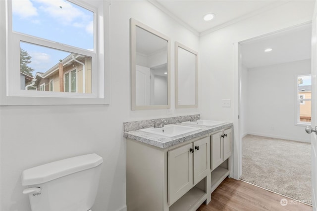 bathroom featuring hardwood / wood-style flooring, toilet, ornamental molding, and a wealth of natural light