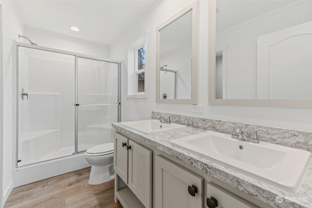 bathroom featuring crown molding, toilet, a shower with shower door, and hardwood / wood-style flooring