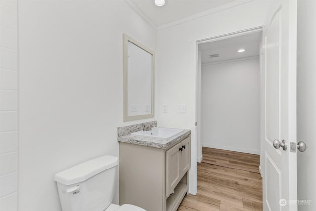 bathroom featuring hardwood / wood-style floors, vanity, toilet, and crown molding