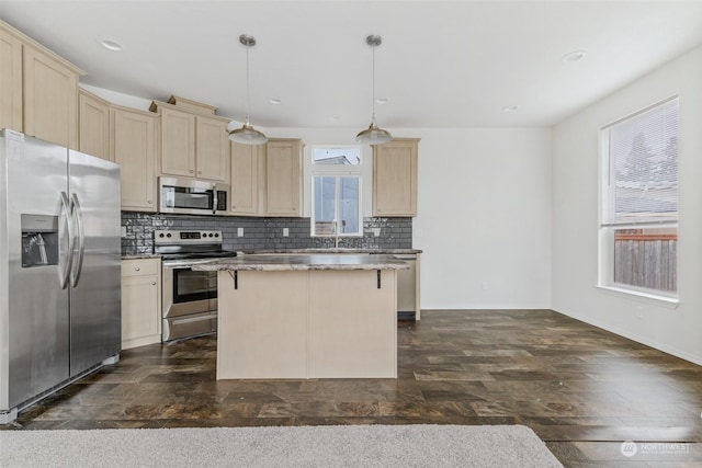 kitchen with pendant lighting, a center island, backsplash, a kitchen breakfast bar, and appliances with stainless steel finishes