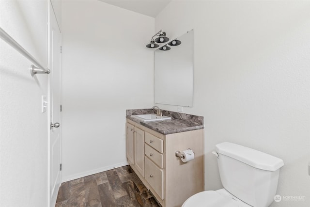 bathroom featuring wood-type flooring, vanity, and toilet