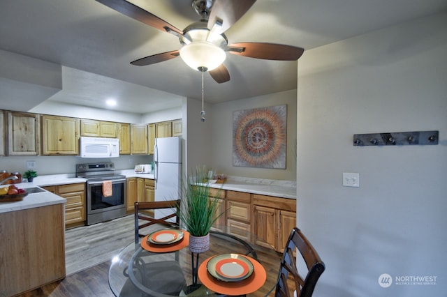 kitchen with ceiling fan, hardwood / wood-style floors, white appliances, and sink