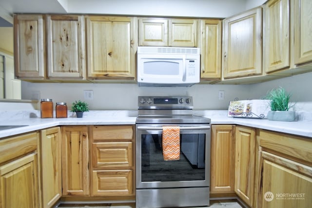 kitchen with stainless steel electric range oven and light brown cabinets