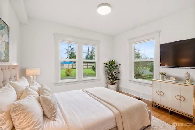 bedroom featuring light hardwood / wood-style flooring and multiple windows