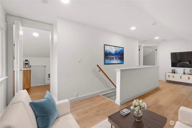 living room featuring light wood-type flooring and vaulted ceiling