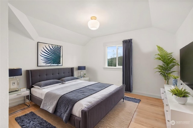 bedroom with light hardwood / wood-style flooring and lofted ceiling