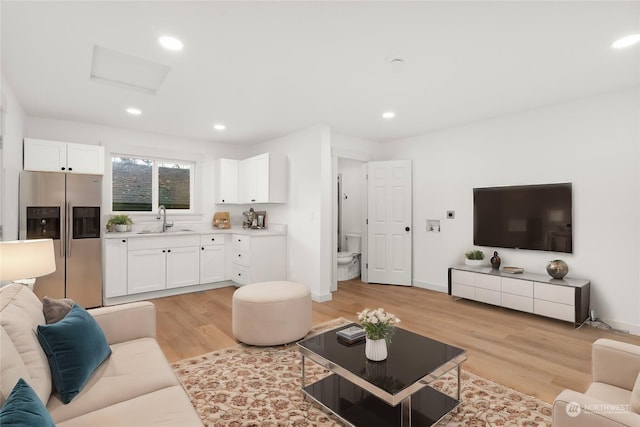 living room with light hardwood / wood-style floors and sink