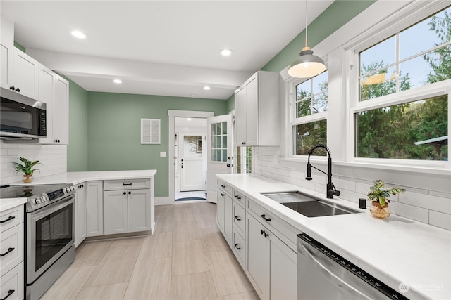 kitchen featuring backsplash, a wealth of natural light, sink, and stainless steel appliances