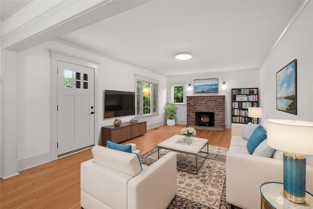 living room with light hardwood / wood-style floors, a brick fireplace, and ornamental molding