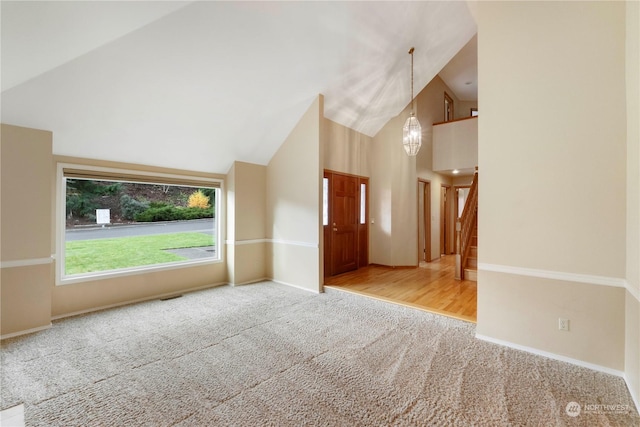 carpeted spare room with lofted ceiling