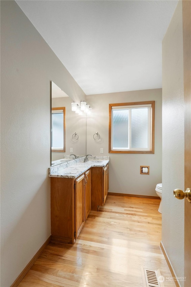 bathroom featuring vanity, hardwood / wood-style flooring, and toilet