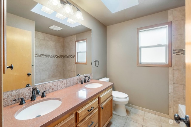 bathroom with toilet, a skylight, tile patterned floors, and a wealth of natural light