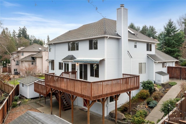 back of house featuring a deck, a storage shed, and a patio area