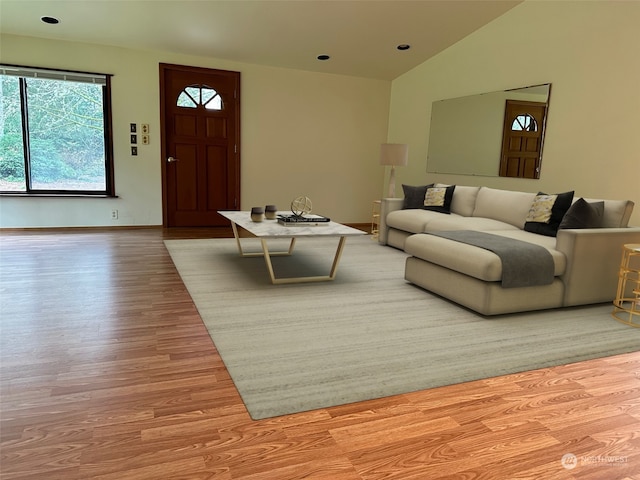 living room with light hardwood / wood-style floors and lofted ceiling