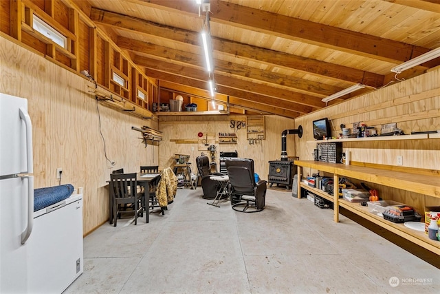 interior space with a workshop area, white fridge, and wood walls