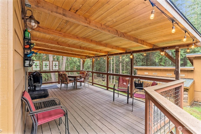 sunroom / solarium featuring beam ceiling and wood ceiling