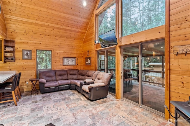 living room featuring high vaulted ceiling, a wealth of natural light, wooden walls, and wood ceiling