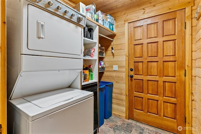 clothes washing area featuring wood walls, stacked washing maching and dryer, and wooden ceiling