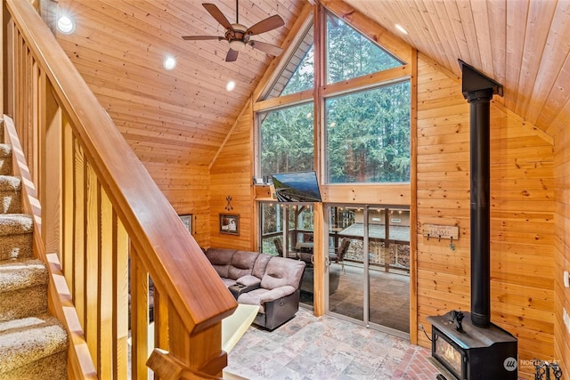 interior space with ceiling fan, wood walls, and wood ceiling