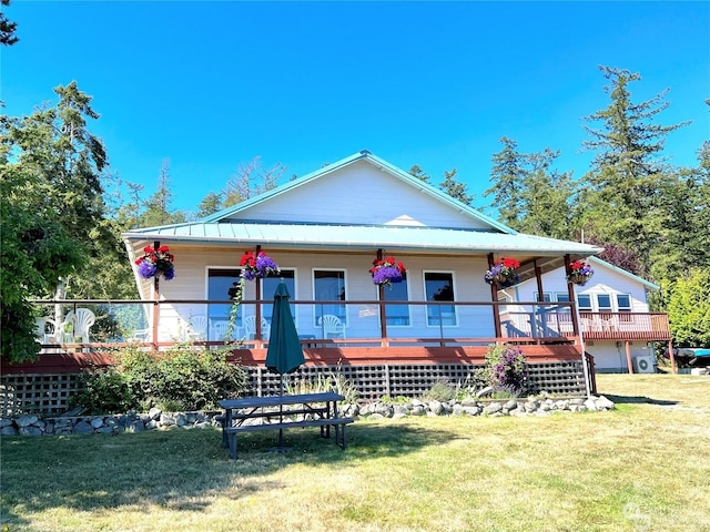 rear view of house with a porch and a yard