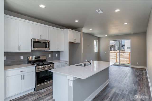 kitchen with white cabinetry, appliances with stainless steel finishes, sink, and a center island with sink