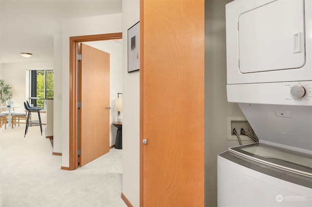 laundry area featuring stacked washer and dryer and light colored carpet