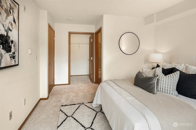 carpeted bedroom with a spacious closet and a closet