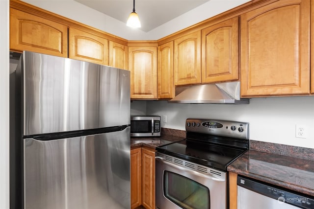 kitchen featuring dark stone counters, stainless steel appliances, and decorative light fixtures