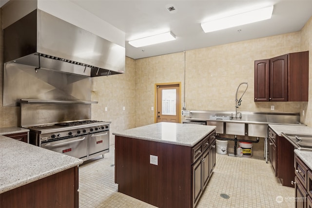 kitchen featuring high end stove, tile walls, and light tile patterned floors