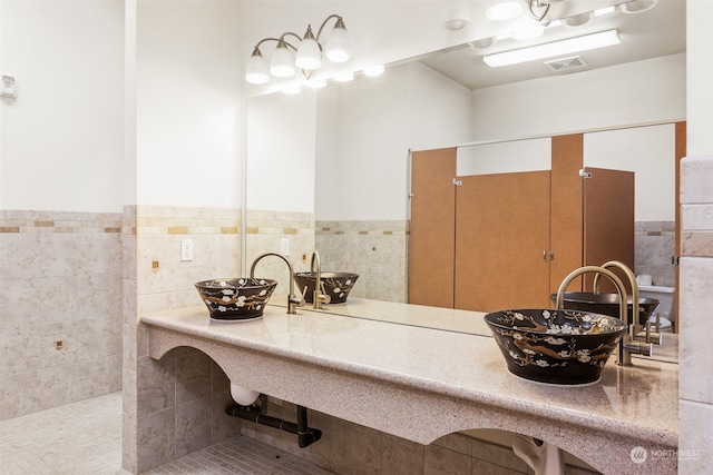 bathroom featuring tile patterned flooring, tile walls, and sink