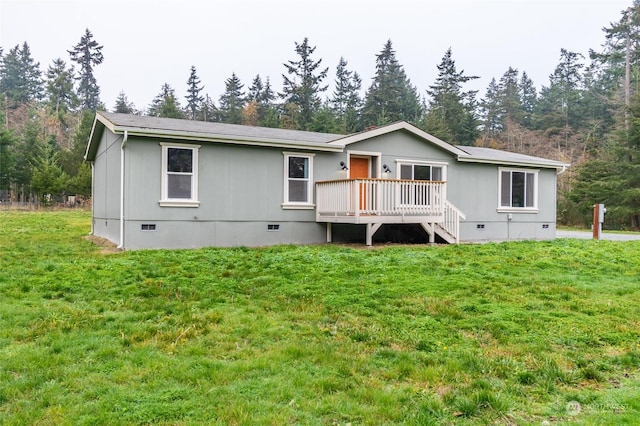 back of house with a lawn and a wooden deck