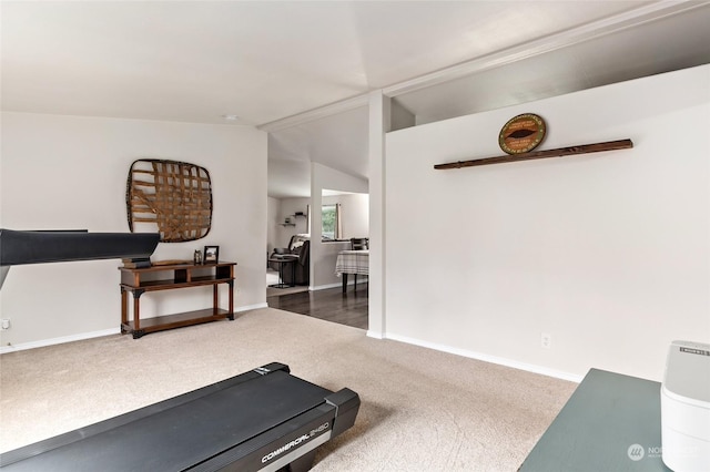 workout area with vaulted ceiling and dark colored carpet