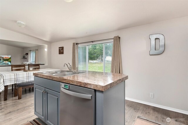 kitchen featuring a center island with sink, dishwasher, sink, and hardwood / wood-style flooring