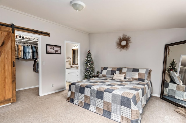 bedroom featuring light carpet, ensuite bathroom, vaulted ceiling, a barn door, and a closet