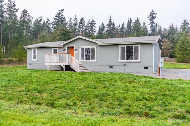 view of front facade featuring a wooden deck and a front lawn