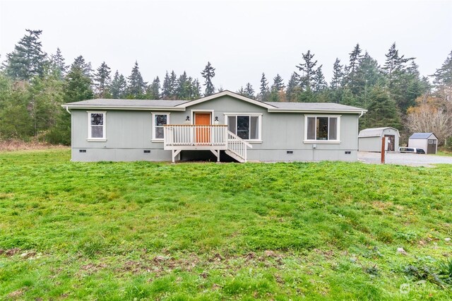 manufactured / mobile home featuring a front lawn, an outdoor structure, and a garage