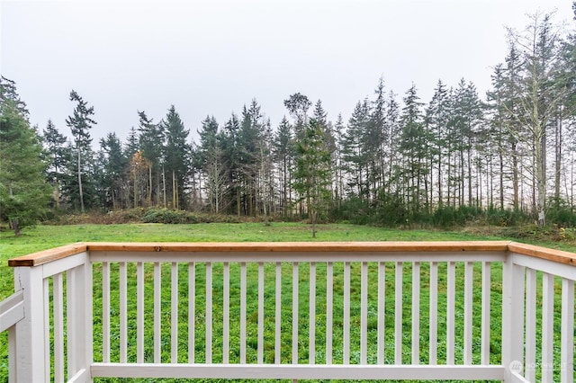 wooden terrace featuring a lawn