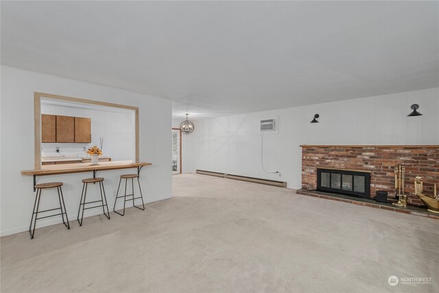 living area with carpet, a baseboard radiator, a brick fireplace, and an AC wall unit