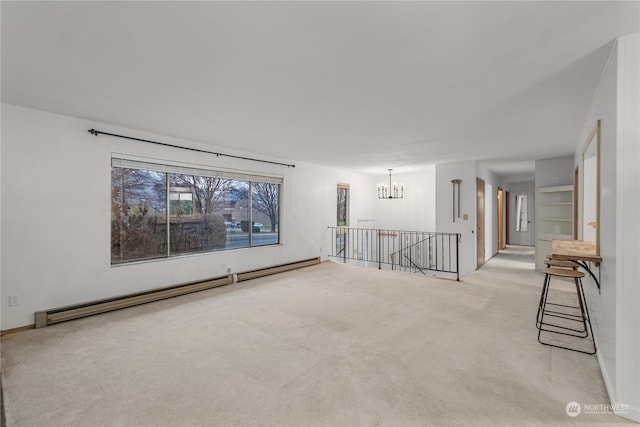 empty room featuring light carpet, a baseboard heating unit, and a chandelier