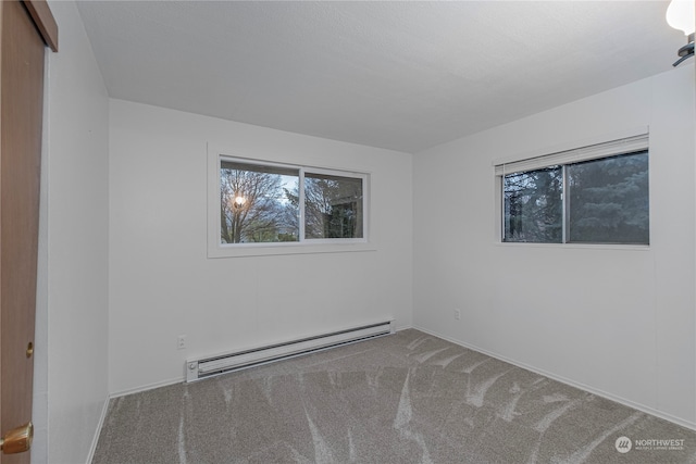 carpeted empty room with a baseboard radiator