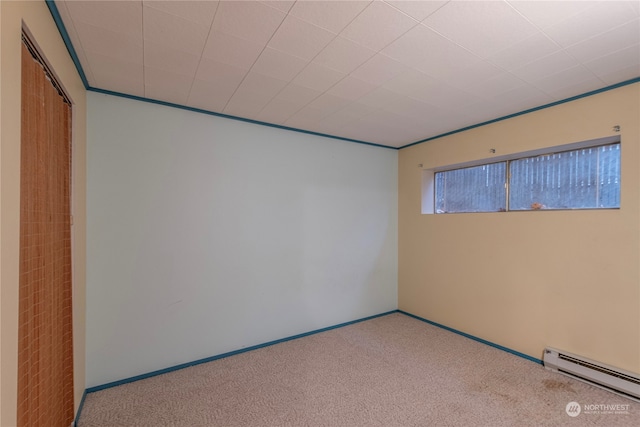 carpeted spare room with a baseboard heating unit and baseboards