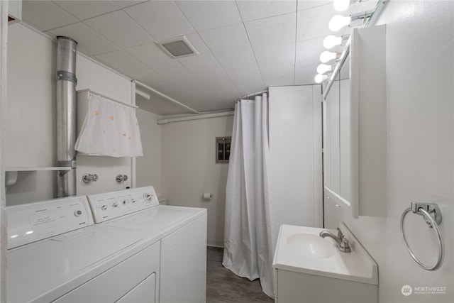 laundry area featuring dark wood-type flooring, washer and dryer, laundry area, and a sink