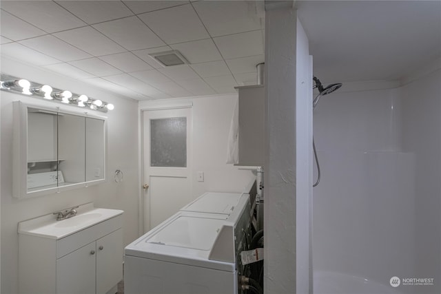 bathroom with washing machine and dryer, walk in shower, and vanity